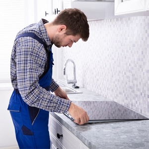 Kỹ thuật viên đang thay mặt kính bếp từ chính hãng tại Hải Phòng
